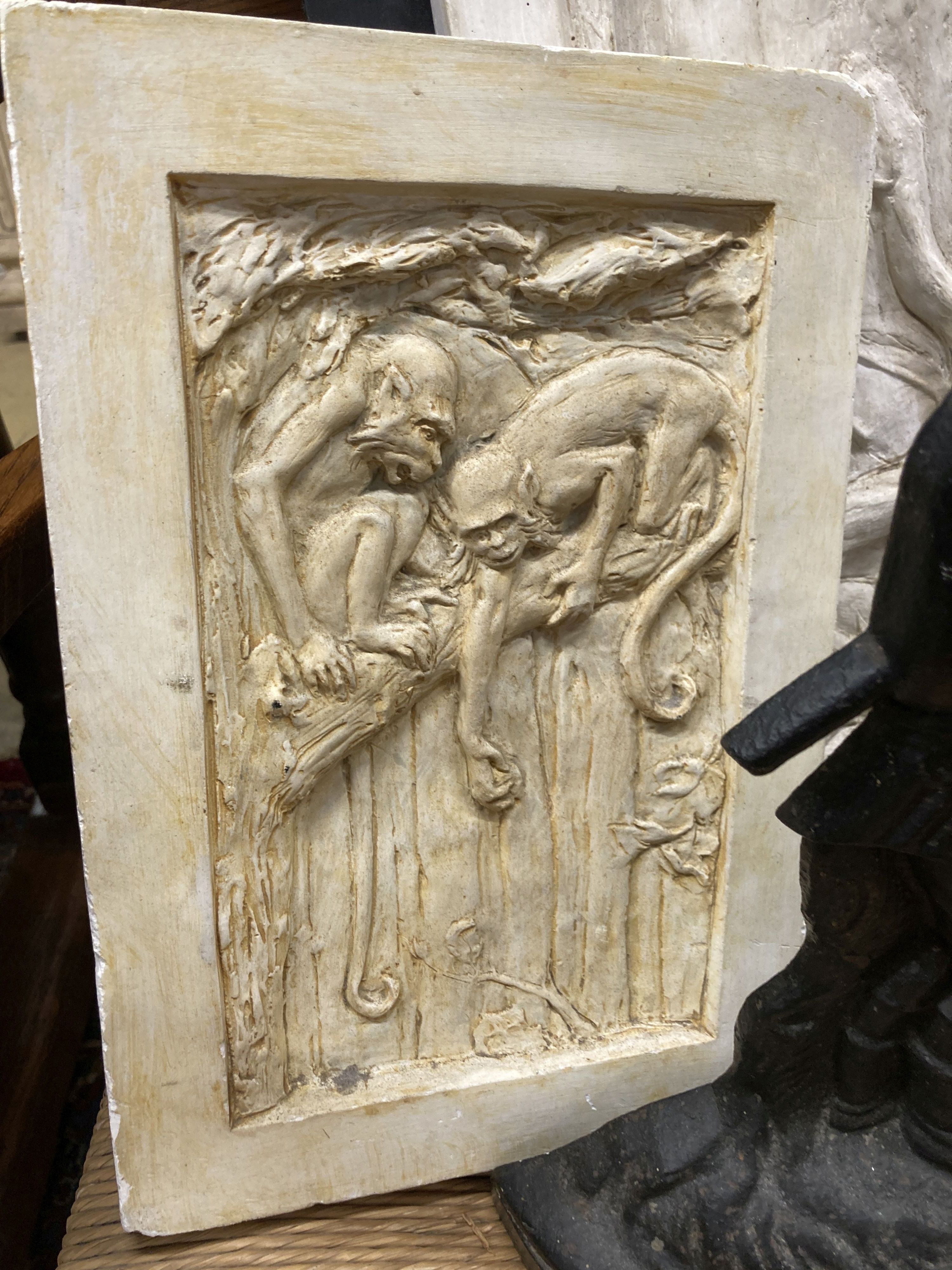 A pair of rectangular cast plaster plaques, larger 59cm high, 22cm wide together with a Victorian style cast iron doorstop